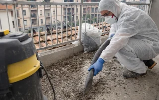 Bonifica professionale del guano dei piccioni accumulato su grondaie e balconi di edifici urbani